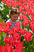 Boy smelling tulips