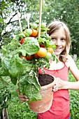 Mädchen hält Tomatenpflanze