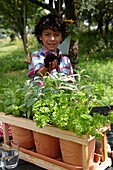 Boy planting herbs on pot