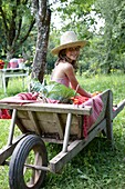 Girl sitting in wheelbarrow
