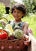 Junge hält Korb mit Gemüse