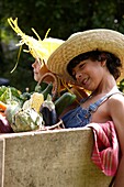 Children holding basket with vegetables