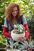 Woman holding pot with Pernettya