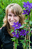 Woman holding Clematis The President