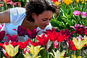 Frau riecht an lilienblütigen Tulpen