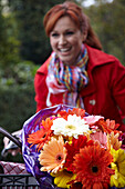 Woman riding bicycle holding flowers