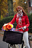Woman riding bicycle holding flowers