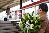 Man welcomes woman with flowers