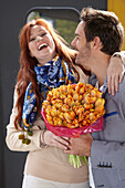 Man welcomes woman with flowers