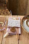 Asian place setting with origami paper banderole and decorative grass