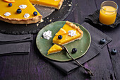 Vegan orange tart with dots of cream and blueberries