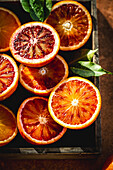 Halved blood oranges with leaves