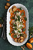 Persimmon salad with feta cheese, pistachios and mint