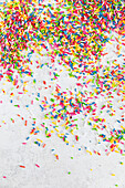 Colourful sugar sprinkles on a white surface