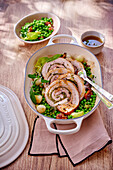 Pork belly roulade with herb filling and pea vegetables