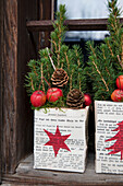 Arrangement of fir branches, pine cones and red baubles, in paper with star decoration