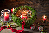 Moss arrangement decorated for Christmas with tea lights and Christmas baubles