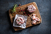 Brie cheese wrapped in bacon on aluminium foil