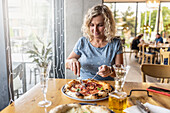 Woman eating spicy salami pizza