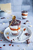 Layered caramel dessert with whipped cream and chocolate