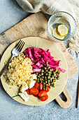 Bulgur dazu fermentierter Kohl, Kapern, Käse und Kirschtomaten