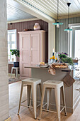 Kitchen island with breakfast and bar stools in country house kitchen