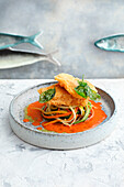 Whitefish piccata on vegetable spaghettini and paprika salsa