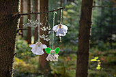 Three handmade flower fairy pendants made of lace and felt in the forest