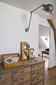 Holzkommode mit Metallgriffen, Vintage-Deko und Wandlampe