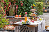 Erntedank-Etagere auf gedeckter Tafel im herbstliche Garten