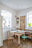 Country-style dining area with rustic wooden table and chairs, wooden bench with fur