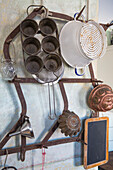 Vintage kitchen utensils on a rustic wall bracket