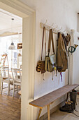 Entrance area with wooden bench and hook rail, country house style