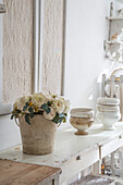 Vintage-Deko mit Rosenbouquet und Keramik auf antikem Tisch