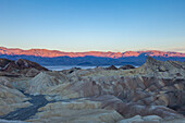 Zabriskie Point, Manly Beacon und die Panamint Mountains bei Sonnenaufgang im Death Valley National Park in Kalifornien