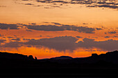 Pastellfarbener Sonnenaufgang mit Virga oder verdunstendem Regen über der Canyonlandschaft bei Moab, Utah