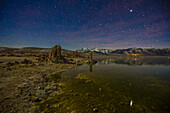 Sterne über mondbeschienenen Tuffsteinformationen im Mono Lake in Kalifornien mit den östlichen Sierra Mountains im Hintergrund