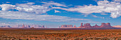 Panoramablick auf das Monument Valley aus nordöstlicher Richtung. L-R: Three Sisters am linken Ende der Mitchell Mesa, East Mitten, Merrick Butte, West Mitten, Gray Whiskers Butte, Mitchell Butte, Sentinal Mesa, Big Indian Chief, Castle Butte, Bear & Rabbit, Stagecoach, King on the Throne, Brigham's Tomb, & Eagle Mesa ganz rechts hinten. Die Grenze zwischen Arizona und Utah verläuft zwischen Mitchell Butte und Sentinal Mesa, fast in der Mitte des Bildes, mit Utah auf der rechten Seite.