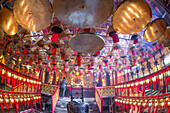 Brennende Weihrauchspulen senden Gebete zum Himmel im Man Mo Tempel, einem buddhistischen Tempel in Hongkong, China. Fotografen nehmen Bilder vom Altar auf.