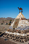 The grave monument for Hadji Ali, or Hi Jolly, in the cemetary in Quartzsite, Arizona with the Dome Rock Mountains behind.