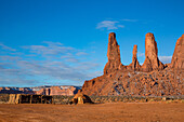 A traditional Navajo hogan in front of the Three Sisters in the Monument Valley Navajo Tribal Park in Arizona.