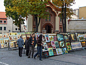 People shop for art in a street market in front of the Church of St. Paraskeva in the Old Town of Vilnius, Lithuania. A UNESCO World Heritage Site. St. Paraskeva is the oldest Eastern Orthodox church in Vilnius.