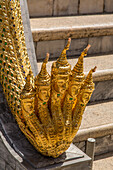 Eine goldene fünfköpfige Naga oder Wassergottheit auf den Stufen des Phra Mondhop im Grand Palace-Komplex in Bangkok, Thailand