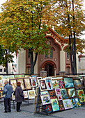 Menschen kaufen auf einem Straßenmarkt vor der Kirche St. Paraskeva in der Altstadt von Vilnius, Litauen, Kunst ein. Eine UNESCO-Welterbestätte. St. Paraskeva ist die älteste orthodoxe Kirche in Vilnius.