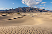 Wellen in den Sanddünen von Mesquite Flat im Death Valley National Park in der Mojave-Wüste, Kalifornien. Dahinter die Panamint Mountains
