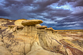 Sandstone caprocks on hoodoos in the colorful clay hills in the badlands of the San Juan Basin in New Mexico.