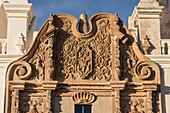Eingeschnitztes Emblem des Franziskanerordens und Jakobsmuschel an der Fassade der Mission San Xavier del Bac, Tucson, Arizona