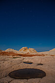 Stars over the moonlit sandstone in the White Pocket Recreation Area, Vermilion Cliffs National Monument, Arizona.