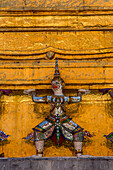 A small yaksha guardian statue at the Temple of the Emerald Buddha complex in the Grand Palace grounds in Bangkok, Thailand. A yaksha or yak is a giant guardian spirit in Thai lore.