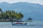 A boatload of tourists return from an ocean excursion at Bahia de Las Galeras on the Samana Peninsula, Dominican Republic.